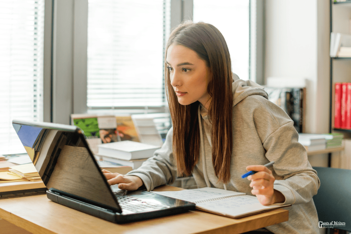 Unterstuetzung Online Klausur. Studentin sitzt vor dem Laptop und schliesst eine Online Prüfung ab.